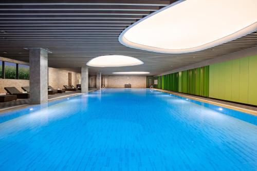 贵阳贵阳青岩假日度假酒店的大楼内一个蓝色的大型游泳池