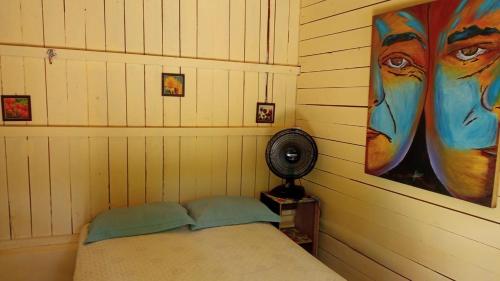贝伦Pousada Grão的一间设有一张床的客房,墙上挂着一幅画