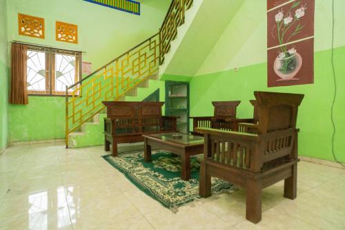 巴图RedDoorz Syariah near Batu Night Spectacular 3的一间带两把椅子和楼梯的客厅