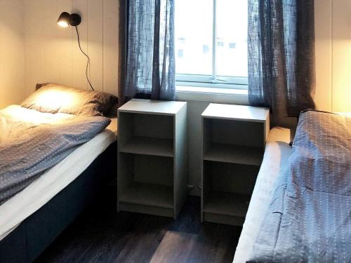 Dyrvik6 person holiday home in Dyrvik的一间卧室设有两张单人床和一个窗户。