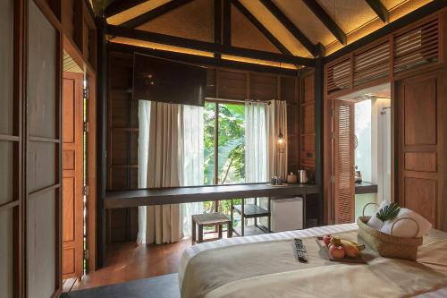 苏梅岛The Spa Resorts - Lamai Village的一间带床的卧室,位于带窗户的房间内