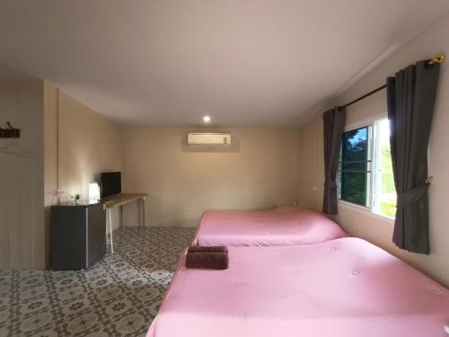 班武里府บ้านในสวนรีสอร์ทBannnaisuan Resort的客房设有两张床和窗户。
