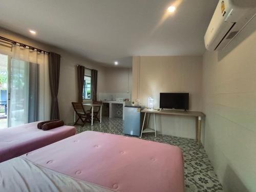 班武里府บ้านในสวนรีสอร์ทBannnaisuan Resort的客房设有两张床和一张书桌及一台电视。