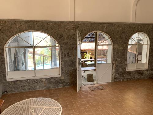 库埃察兰德尔普罗格雷索Posada Quetzalin的一间设有两个拱形窗户和一扇门的房间