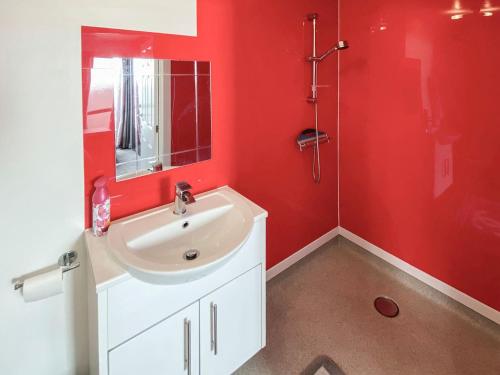 大雅茅斯Thistle Dew的红色的浴室设有水槽和淋浴