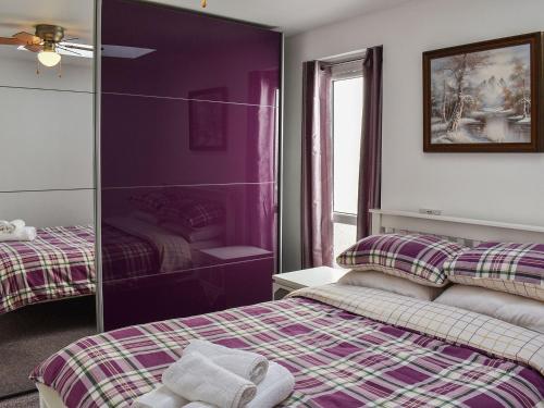 大雅茅斯Thistle Dew的紫色的客房配有两张床和镜子