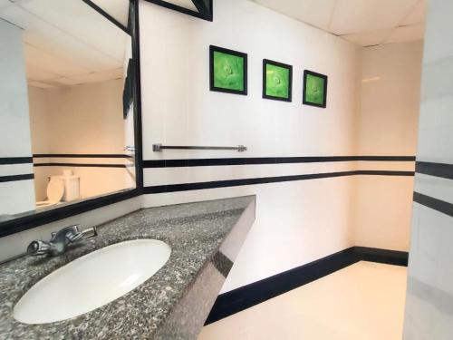 丹绒武雅Seaview Suite at Rainbow Paradise的一间带水槽和镜子的浴室