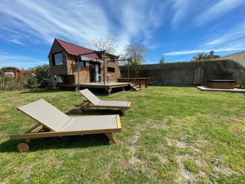 艾格-莫尔特myinsolite - Tiny-house, jacuzzi, brasero, piscine的后院设有两张野餐桌和一个小房子