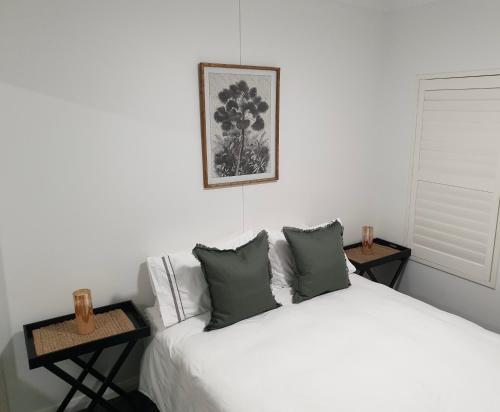 凯阿玛The Tribe House Kiama的卧室配有白色的床和2张桌子