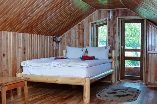 GarmakiRodovoe Gnezdo Garmaki的卧室配有一张床铺,位于带木墙的房间内