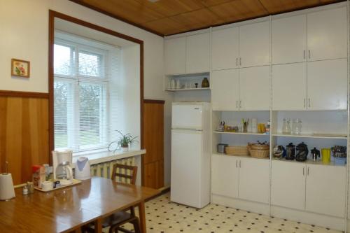 KihelkonnaKihelkonna Pastorate Guesthouse的厨房配有桌子和白色冰箱。