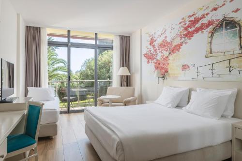 布德瓦Iberostar Bellevue All Inclusive的卧室设有白色的床和大窗户