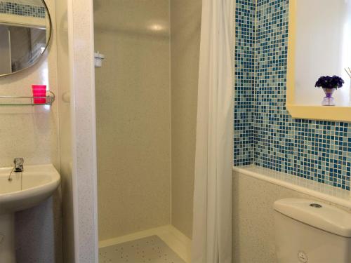 班夫Coldhome Cottage的带淋浴、卫生间和盥洗盆的浴室