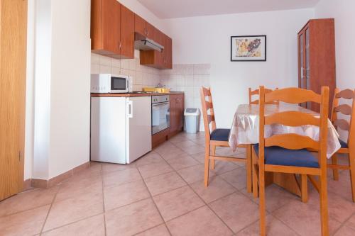 普利拉卡Apartments Sunset -near Queen Beach的厨房配有桌椅和微波炉。