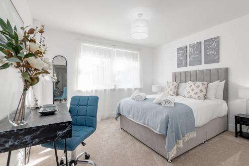 圣安德鲁斯Skye Sands - City Road Residence - Central St Andrews的一间卧室配有一张床、一张桌子和一把椅子