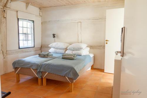 NyordRagnhilds Gård, Hostel的一间卧室配有带白色床单和枕头的床。