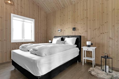 BrautarholtLuxury Country Cottage with 360° Mountain View的卧室设有一张白色大床和一扇窗户。