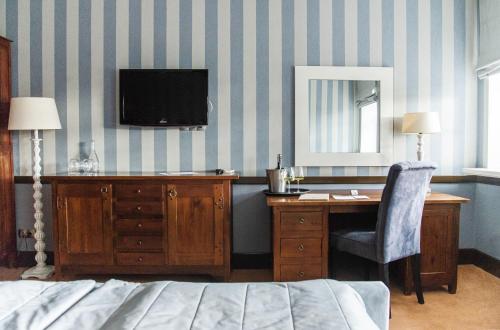 Wierzchowiska德沃尔桑纳酒店的一间卧室配有书桌,墙上配有电视