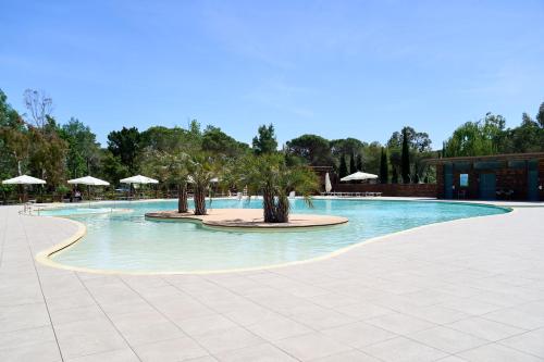 瓦达Camping Campo dei Fiori的一座带树木和遮阳伞的大型游泳池