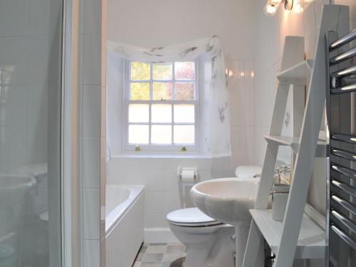 UrrayGlebe Cottage的白色的浴室设有盥洗盆、卫生间和窗户。