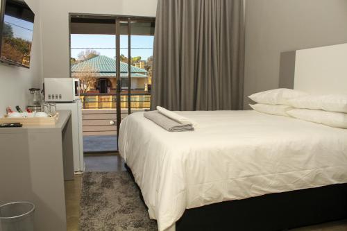 鲁德普特Alu Boutique Hotel and Conference的卧室配有白色的床和窗户。