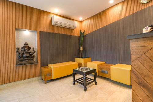 古尔冈FabHotel RR Residency的一间设有黄色椅子和空调的等候室