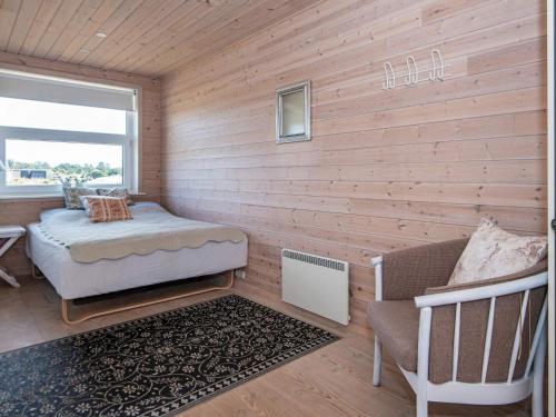 凡岛Holiday home Fanø CLXXVIII的客房设有床、椅子和窗户。