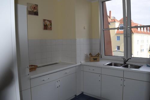 奥斯赛拜-屈隆斯博恩Kühlungsborner Brauhaus的白色的厨房设有水槽和窗户