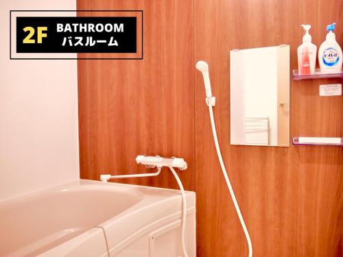大阪Jen's House Osaka的浴室设有白色浴缸,毗邻镜子