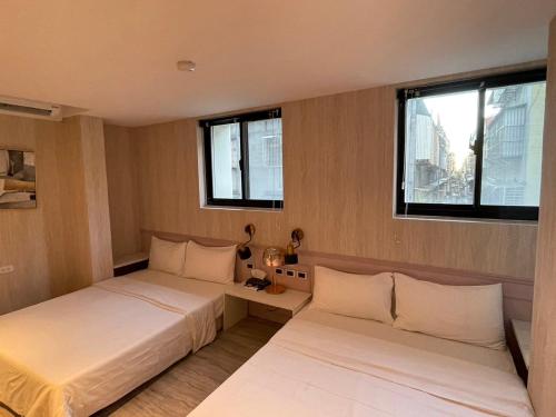 台北Sunrise Hotel的带2扇窗户的客房内的2张床