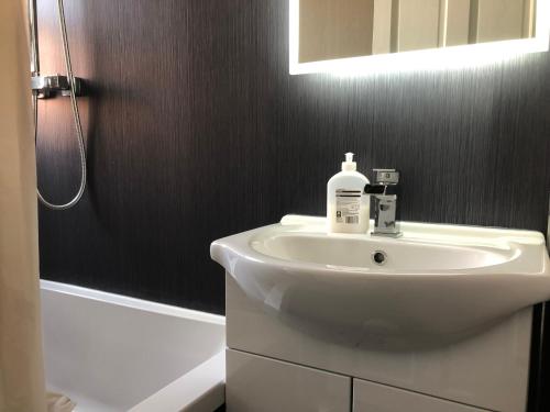 柯科迪Captivating 2-Bed Apartment in Kirkcaldy的浴室配有白色水槽和淋浴。