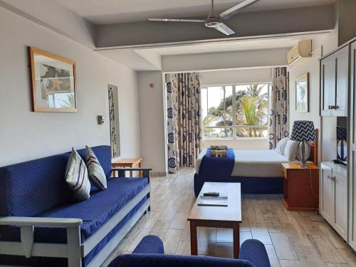 德班Gooderson Leisure Silver Sands 2 Self Catering and Timeshare Lifestyle Resort的客厅配有蓝色的沙发和床。