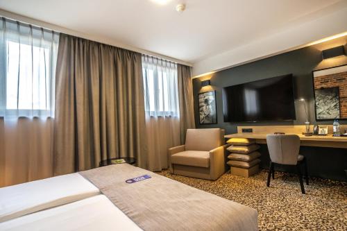 格但斯克格但斯克库布斯酒店的配有一张床和一张书桌的酒店客房