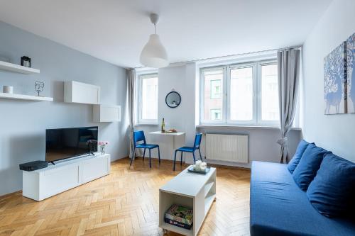 华沙Śliska 10 Prywatne mieszkanie 300m od Dworca Centralnego oraz metra ONZ的客厅配有蓝色的沙发和桌子