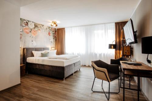奥斯纳布吕克韦斯特卡普酒店的配有一张床和一张书桌的酒店客房