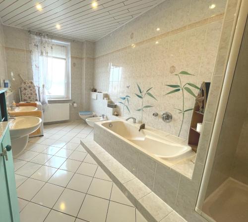汉诺威Attraktive 2 Zimmer Wohnung in Toplage, Nähe Messe的一间带两个水槽、一个浴缸和两个卫生间的浴室