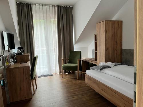 梅彭Hotel Knotenpunkt的一间卧室配有一张床、一张桌子和一把椅子