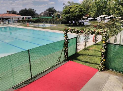 马尔帕尔蒂达德卡塞雷斯Hotel Peña Cruz的一座游泳池,在围栏旁铺有红地毯