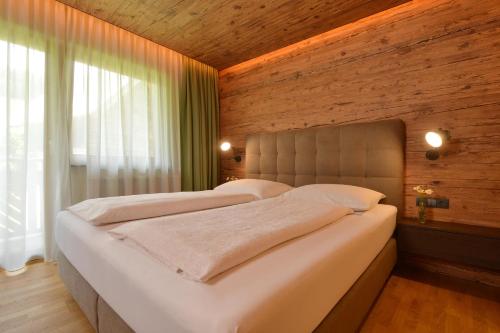 茵特斯托德Landhotel Gressenbauer的一间卧室设有两张床和木墙