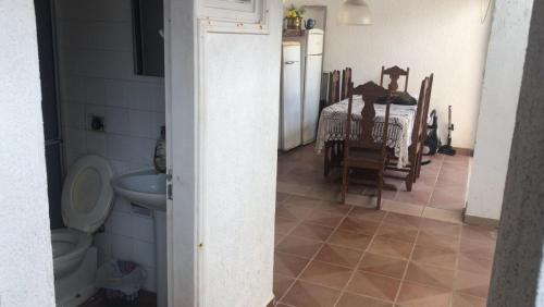 伊塔尼亚恩Hostel Pé na Areia的一间带卫生间的浴室和一间带桌子的厨房