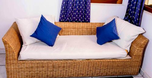 布琼布拉Kiriri Residence Hotel的藤椅和两个蓝色枕头