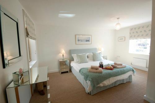 绍斯沃尔德The Shelduck, Southwold的一间卧室配有一张床和一张桌子,上面配有毛巾