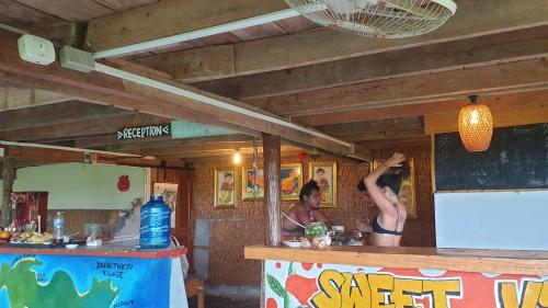 西哈努克Sweet jungle sea view bungalows的两个男人站在餐厅柜台