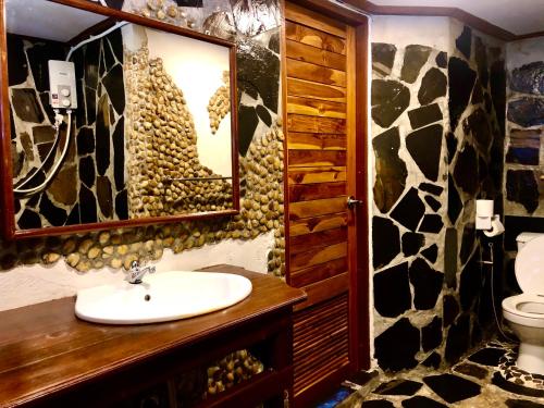 象岛阁昌岛班查蕾度假村的浴室设有水槽和牛花纹墙