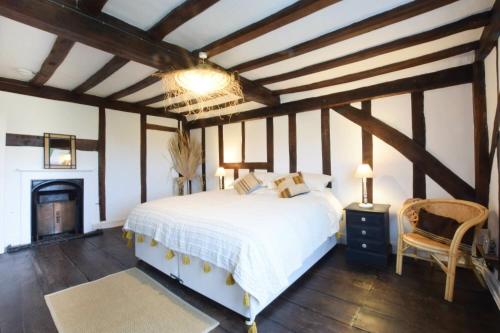 黑尔斯沃思Church Farmhouse, Cookley的卧室配有白色的床和壁炉