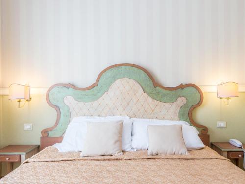 罗马Il乔托帕多瑞莱斯酒店的卧室配有带白色枕头的大床