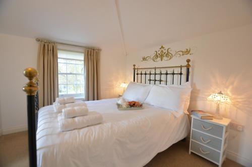 绍斯沃尔德Ferry Cottage, Southwold的卧室配有白色床和毛巾