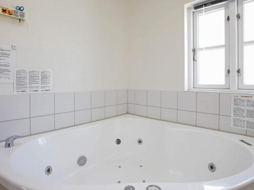 布拉万德4 person holiday home in Bl vand的带窗户的浴室内的白色浴缸