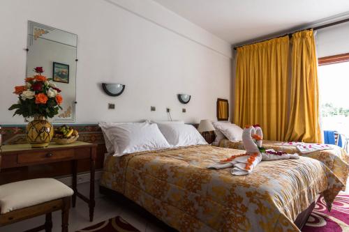 阿加迪尔辛德巴酒店的卧室里设有一张床,上面有一只动物