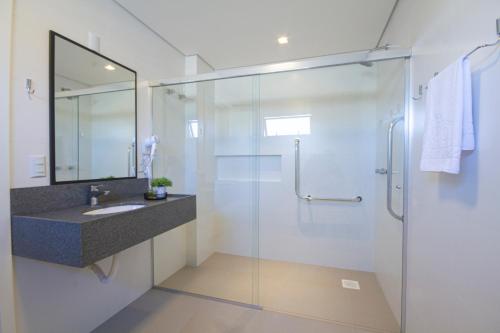 克里西玛Hotel Darolt Criciúma的一间带玻璃淋浴和水槽的浴室